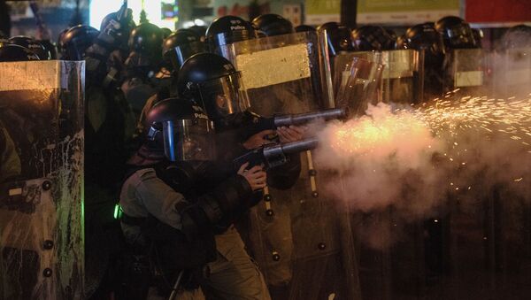 Сотрудники полиции обстреливают антиправительственных демонстрантов слезоточивым газом в Гонконге. - Sputnik Кыргызстан