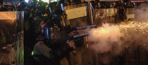 Сотрудники полиции обстреливают антиправительственных демонстрантов слезоточивым газом в Гонконге. Сотрудники полиции обстреливают антиправительственных демонстрантов слезоточивым газом в Гонконге. - Sputnik Кыргызстан