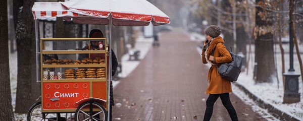 Девушка идет по бульвару Эркиндик во время снегопада в Бишкеке - Sputnik Кыргызстан