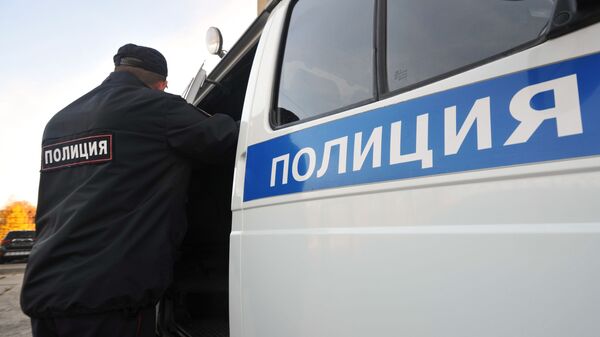 Сотрудник полиции возле служебного автомобиля. Архивное фото - Sputnik Кыргызстан