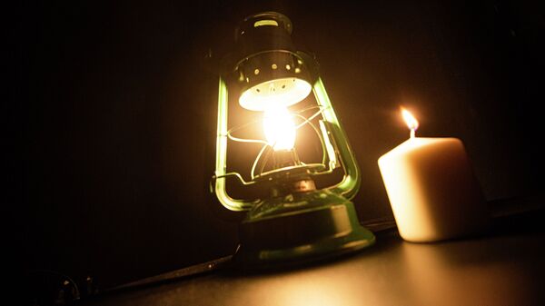 Горящая электрическая лампа и свеча. Иллюстративное фото - Sputnik Кыргызстан