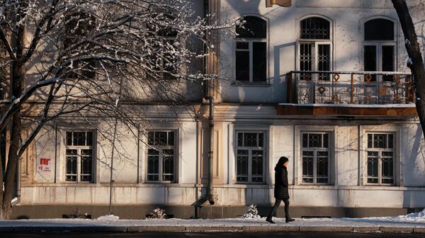 Девушка идет мимо здания в Бишкеке. Архивное фото  - Sputnik Кыргызстан