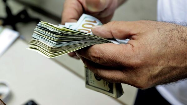 Мужчина пересчитывает купюры долларов США. Архивное фото - Sputnik Кыргызстан