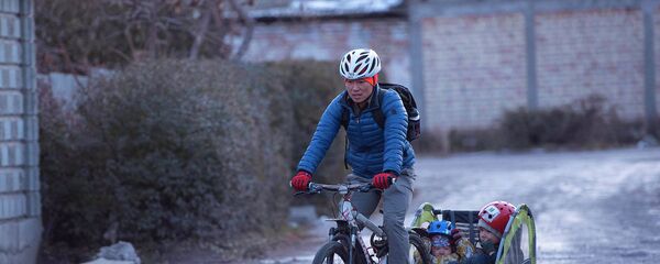 Балдарын велосипед менен ташып... Булганган аба менен күрөшкөн атанын видеосу - Sputnik Кыргызстан