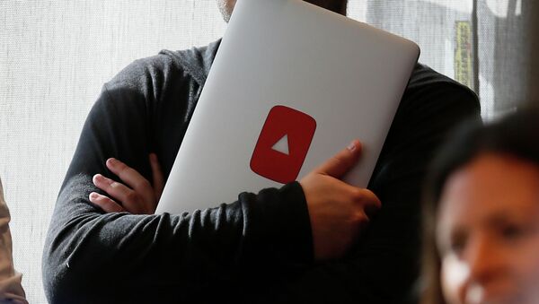 Мужчина держит ноутбук с логотипом YouTube. Архивное фото - Sputnik Кыргызстан