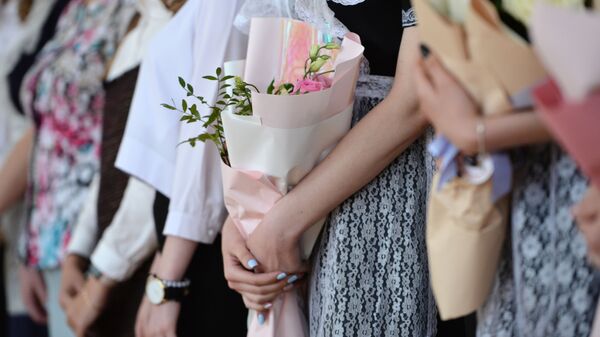 Цветы в руках школьников во время последнего звонка. Архивное фото - Sputnik Кыргызстан