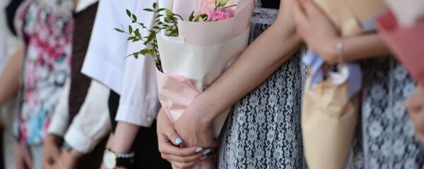 Цветы в руках школьников во время последнего звонка. Архивное фото - Sputnik Кыргызстан