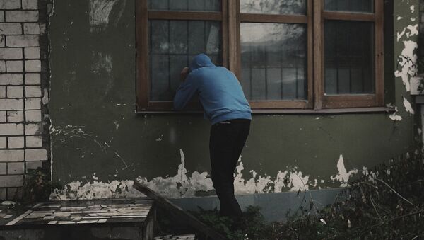 Мужчина смотрит в окно частного дома. Архивное фото - Sputnik Кыргызстан