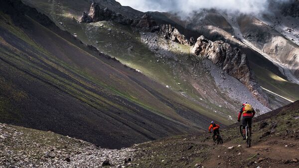 Путешественники едут на велосипедах по Алайским горам, Кыргызстан. Архивное фото - Sputnik Кыргызстан