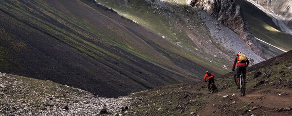 Путешественники едут на велосипедах по Алайским горам, Кыргызстан. Архивное фото Путешественники едут на велосипедах по Алайским горам, Кыргызстан. Архивное фото - Sputnik Кыргызстан