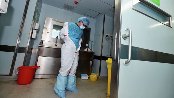 Медицинский работник снимает защитный костюм. Архивное фото - Sputnik Кыргызстан