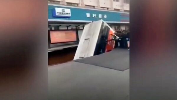Автобус с людьми ушел под землю на остановке в Китае — шокирующее видео - Sputnik Кыргызстан