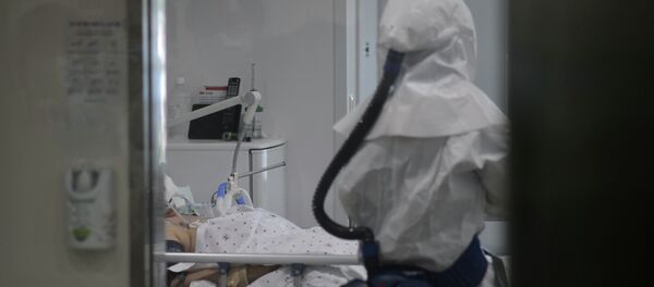 Медицинский работник в защитном костюме входит в комнату пациента зараженного неизвестным вирусом. Архивное фото - Sputnik Кыргызстан