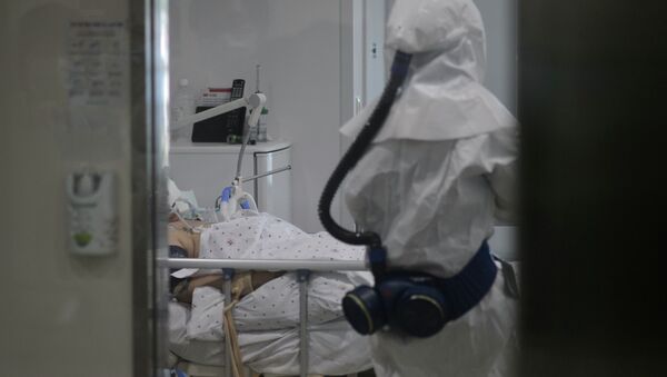 Медицинский работник в защитном костюме входит в комнату пациента. Архивное фото - Sputnik Кыргызстан