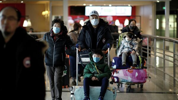 Туристы из рейса Air China из Пекина надевают защитные маски по прибытии в аэропорт имени Шарля де Голля в Париже, Франция, 26 января 2020 года - Sputnik Кыргызстан