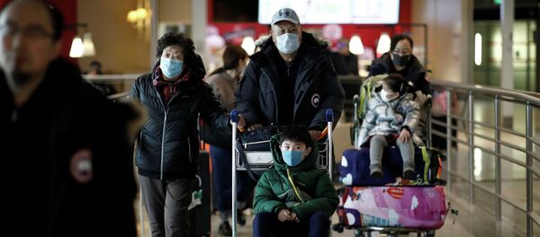 Туристы из рейса Air China из Пекина надевают защитные маски по прибытии в аэропорт имени Шарля де Голля в Париже, Франция, 26 января 2020 года - Sputnik Кыргызстан