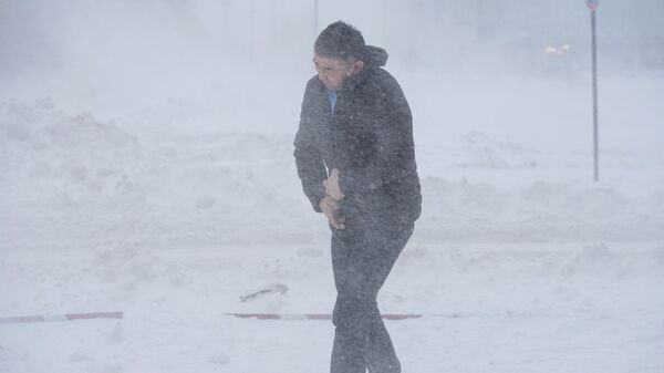 Мужчина идет по улице во время снежной метели в Нур-Султане - Sputnik Кыргызстан