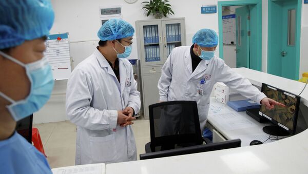 Врачи смотрят на экран, на котором показано отделение, где лежат пациенты инфицированные коронавирусом, Ухань, Китай. 28 января 2020 года - Sputnik Кыргызстан