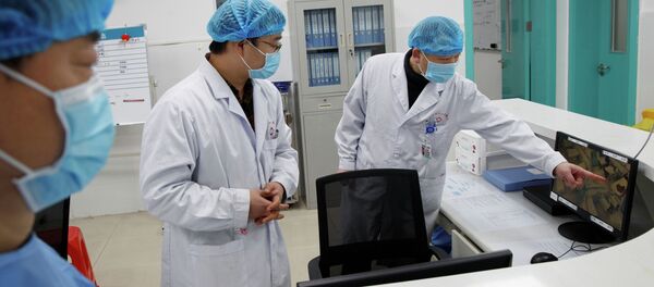 Врачи смотрят на экран, на котором показано отделение, где лежат пациенты инфицированные коронавирусом, Ухань. Китай - Sputnik Кыргызстан