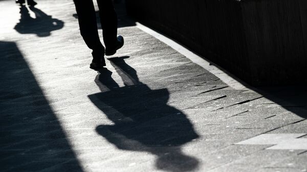 Мужчина отбрасывает длинную тень на тротуар. Архивное фото - Sputnik Кыргызстан