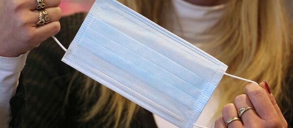 Аял медициналык бет капты кармап турат. Архив - Sputnik Кыргызстан