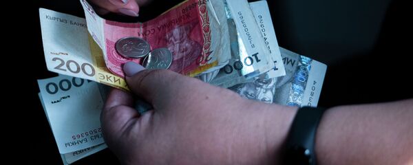 Женщина держит сомовые купюры и монеты в руках. Архивное фото - Sputnik Кыргызстан