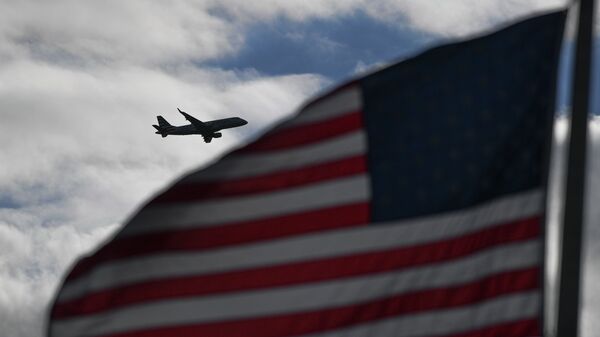 Флаг США на фоне пролетающего самолета. Архивное фото - Sputnik Кыргызстан