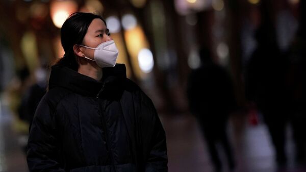 Девушка в медицинской маске в Китае. Архивное фото - Sputnik Кыргызстан