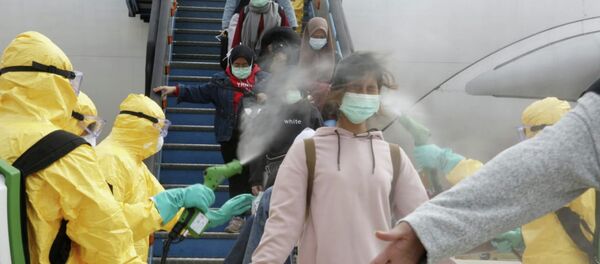 Индонезийцев, прибывших из Уханя, опрыскивают антисептиком в аэропорту Ханг-Надим. - Sputnik Кыргызстан