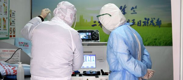 Медицинские работники в защитных костюмах осматривают оборудование в комнате для сдачи крови в больнице. Архивное фото - Sputnik Кыргызстан