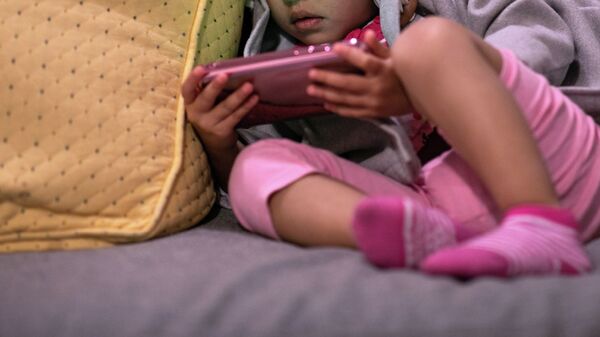 Девочка смотрит мультфильм на телефоне. Архивное фото - Sputnik Кыргызстан