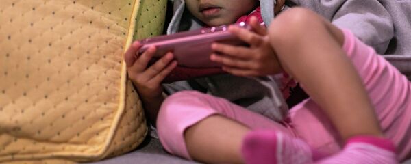 Девочка смотрит видео на телефоне. Архивное фото Девочка смотрит видео на телефоне. Архивное фото - Sputnik Кыргызстан
