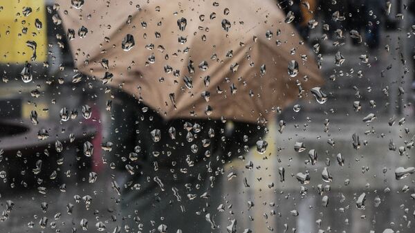 Девушка стоит с зонтом во время дождя. Архивное фото - Sputnik Кыргызстан