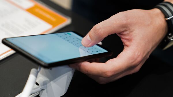 Посетитель осматривает смартфон в магазине Xiaomi. Архивное фото - Sputnik Кыргызстан