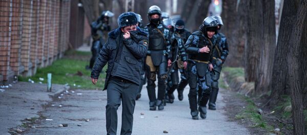 Сотрудник правоохранительных органов закрывает лицо от слезоточивого газа во время силового разгона сторонников Садыра Жапарова в Бишкеке - Sputnik Кыргызстан