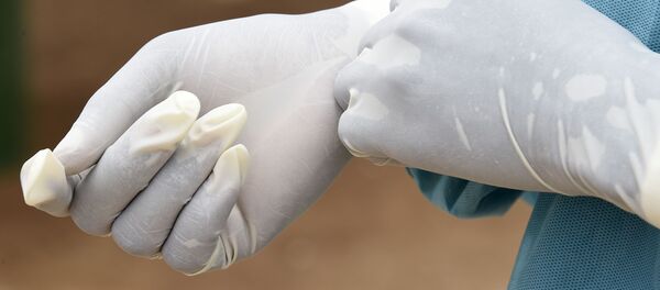 Медицинский работник надевает медицинские перчатки перед началом работы. Архивное фото - Sputnik Кыргызстан