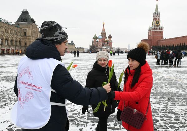 Волонтер дарит цветы и поздравляет женщин с Международным женским днем на Красной площади - Sputnik Кыргызстан