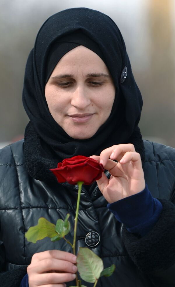 Женщина с розой 8 марта на одной из улиц Грозного - Sputnik Кыргызстан