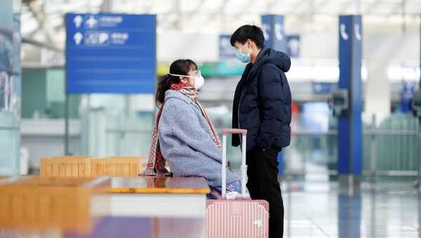 Молодой парень и девушка в медицинских масках в аэропорту. Архивное фото - Sputnik Кыргызстан