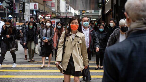 Горожане в защитных масках на одной из улиц в Гонконге. Архивное фото - Sputnik Кыргызстан
