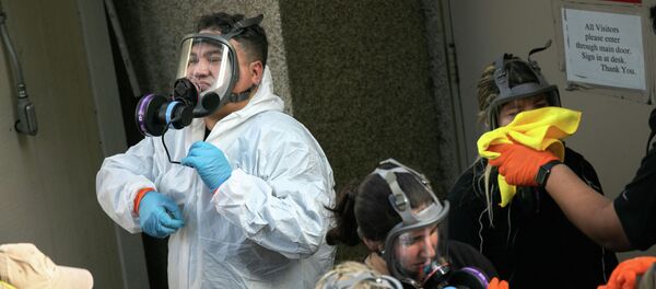 Бригада уборщиков снимает защитную одежду после дезинфекции помещения. Архивное фото - Sputnik Кыргызстан