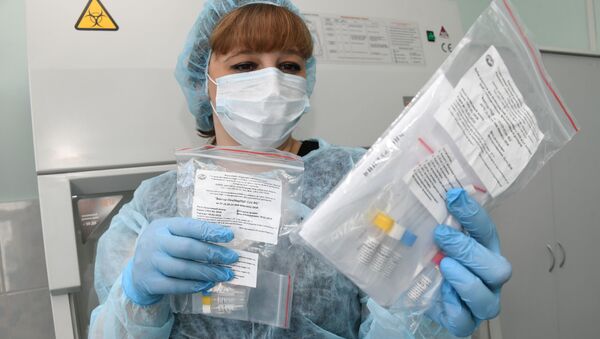 Медицинский сотрудник держит в руках тест на выявление коронавируса - Sputnik Кыргызстан
