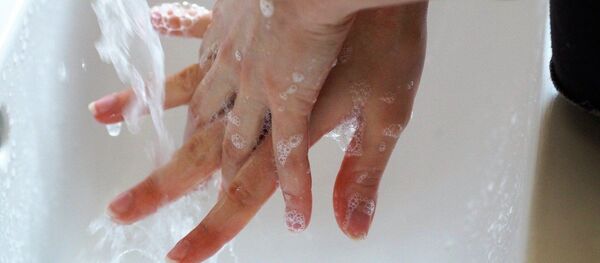 Аял раковинада самын менен колун жууп жатат. Иллюстративдик сүрөт - Sputnik Кыргызстан