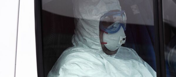 Медицинский работник в защитном костюме в машине скорой помощи. Архивное фото - Sputnik Кыргызстан