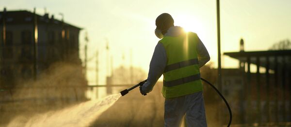 Рабочий дезинфицирует улицу из-за вспышки коронавируса в Италии Рабочий дезинфицирует улицу из-за вспышки коронавируса в Италии - Sputnik Кыргызстан