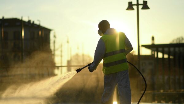 Рабочий дезинфицирует улицу из-за вспышки коронавируса, Милан, Италия - Sputnik Кыргызстан