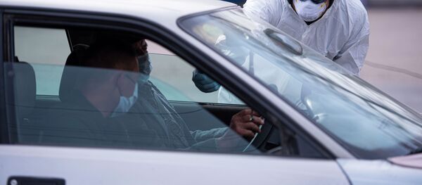 Медициналык кызматкер тепловизор менен айдоочунун температурасын текшерип жатат блокпостто. Архив - Sputnik Кыргызстан