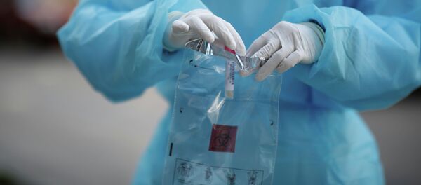 Медсотрудник с анализом на коронавирусную болезнь (COVID-19) в лаборатории - Sputnik Кыргызстан