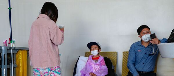 Киши балдары менен медициналык бет капчан аэропортто отуруп жатат. Архив Киши балдары менен медициналык бет капчан аэропортто отуруп жатат. Архив - Sputnik Кыргызстан