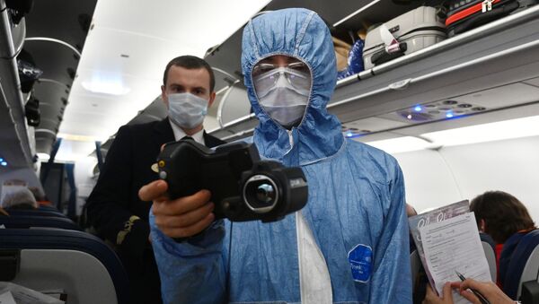 Медицинский сотрудник проверяет тепловизором температуру у пассажиров. Архивное фото - Sputnik Кыргызстан
